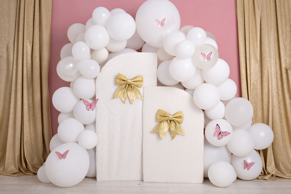 pink white gold cake smash setup with white balloons and gold bows