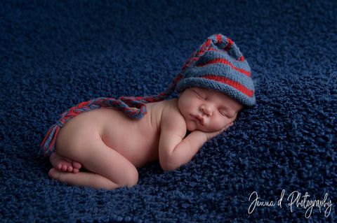 baby boy on bean bag blue an red newborn hat in pretoria photo studio