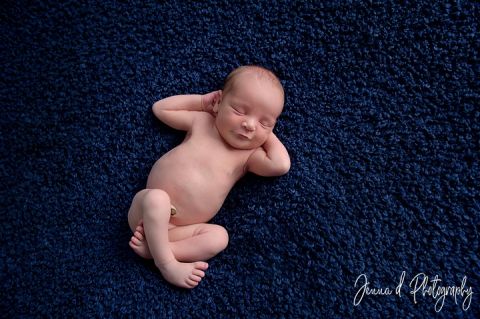 newborn baby photo of a boy on a blue backdrop in the studio