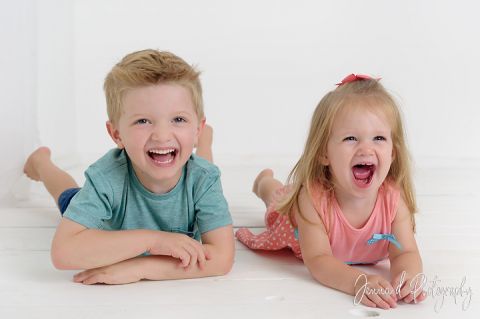 brother and sister taking sibling photos in photo studio