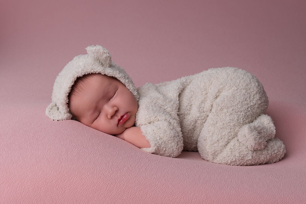 gentle sleep training for newborn on her tummy on pink