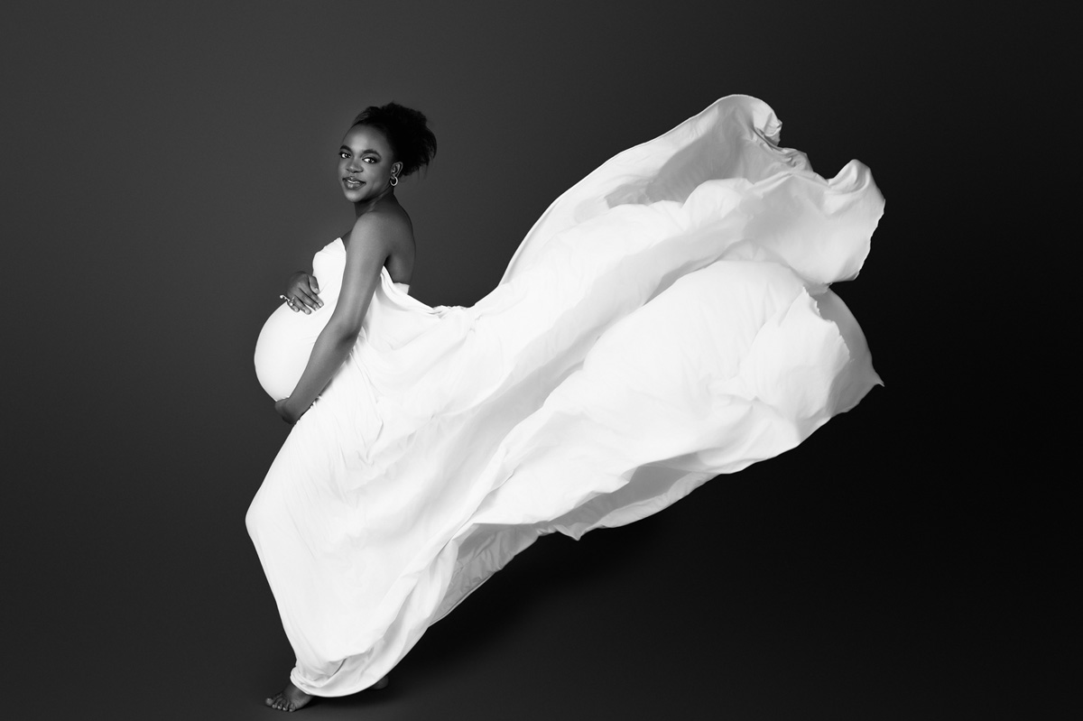 Soft maternity portrait of a pregnant woman white dress, used to complement information about 3D/4D scans in Pretoria