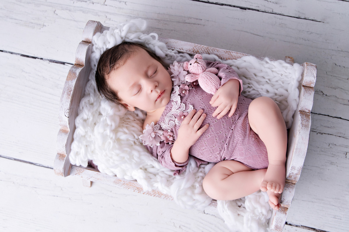 baby girl on tiny newborn bed