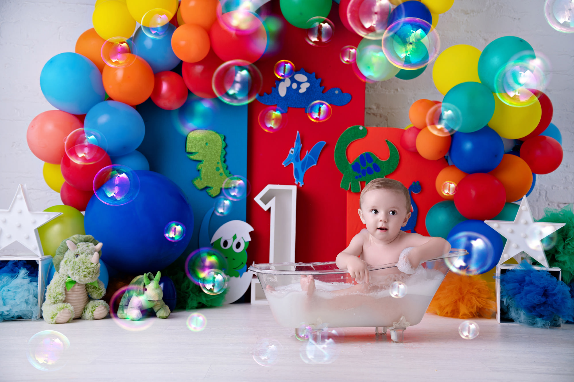 baby in red and yellow setup enjoying a milk bath