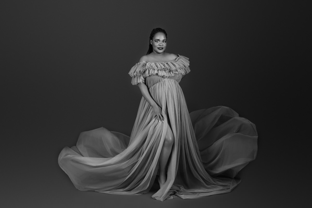 Black and white maternity portrait of an expecting mother in a flowing gown, reflecting the calm, supportive environment of Pretoria midwife-led birth centres