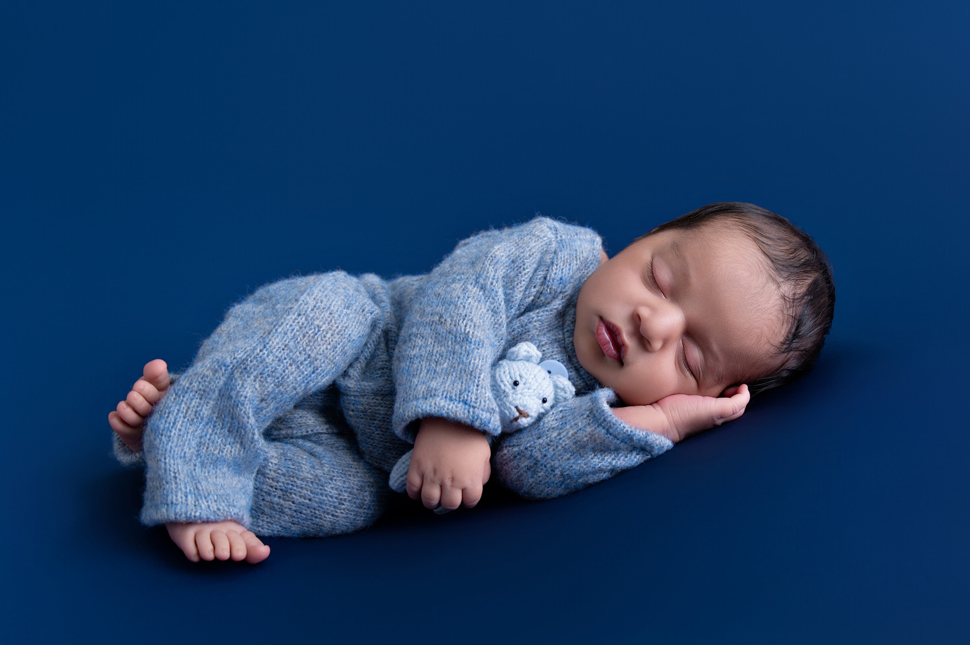 Studio newborn portrait of baby boy sleeping on dark blue backdrop – Pretoria newborn photography.