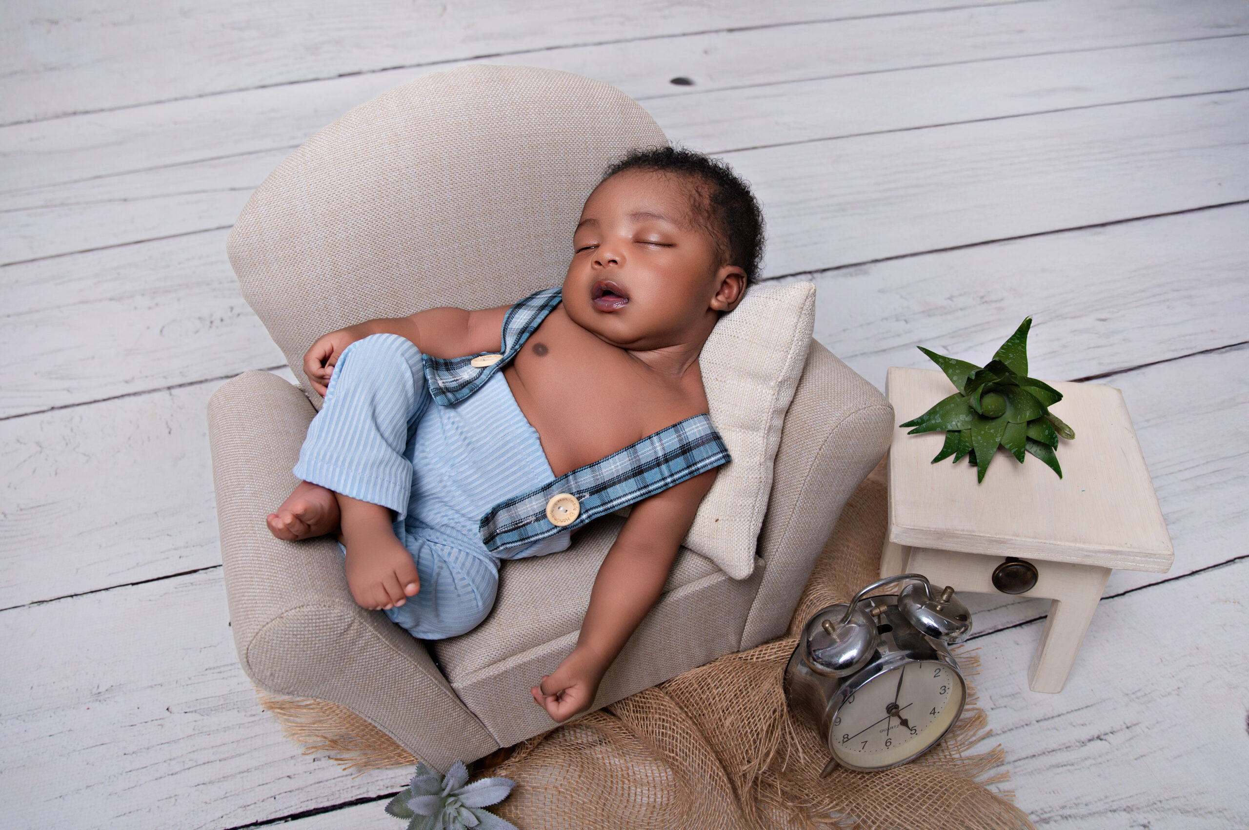 baby sleeping on a small little chair baby props