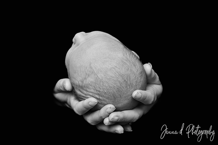 babies head in daddy's hands black and white photos