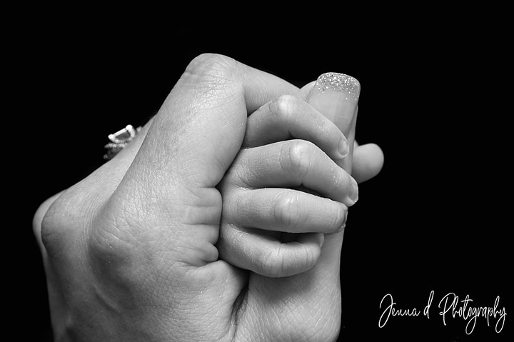 babies hand held by mommies hand, black and white photo