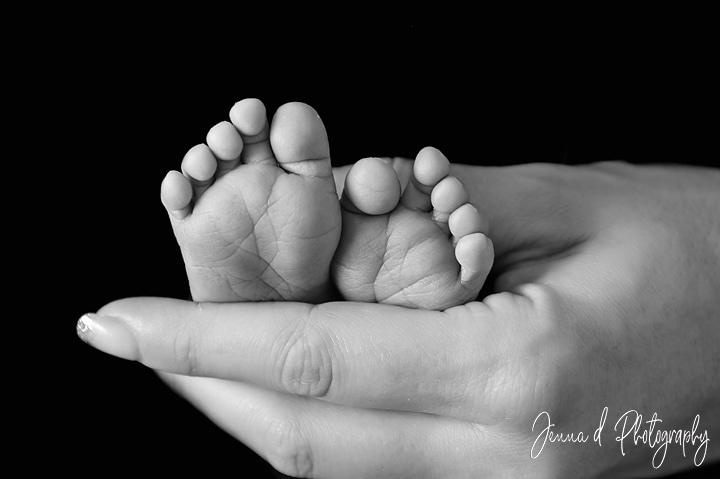 babies feet in mommy's hands