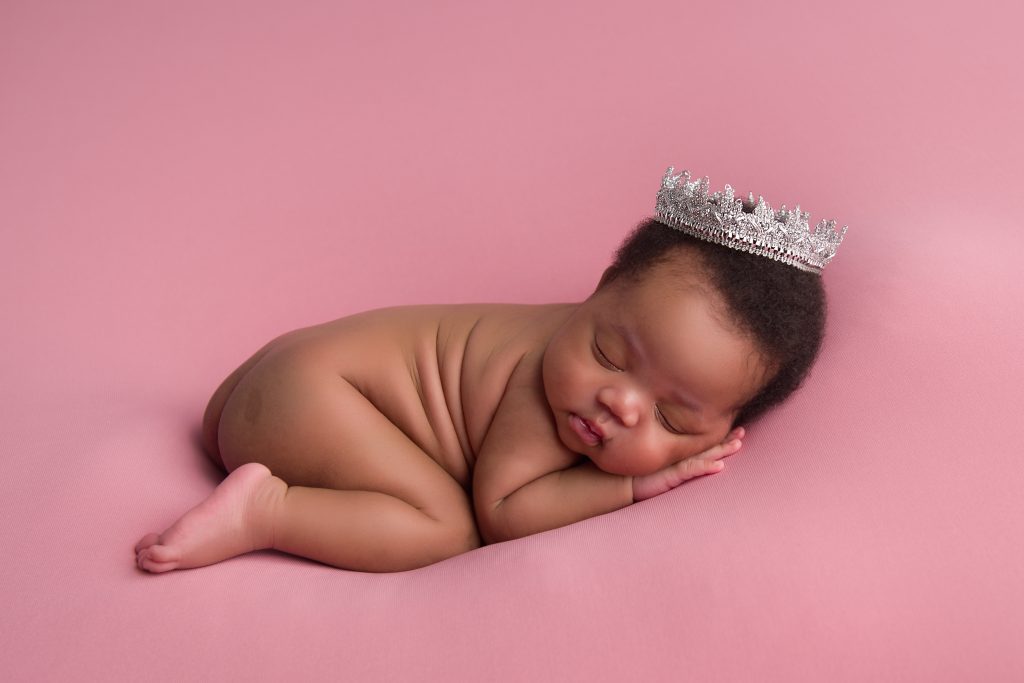 baby girl on pink backdrop with cute silver crown
