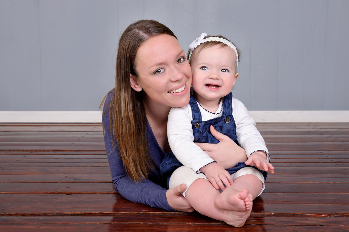 Mother sitting with baby during relaxed family portrait,