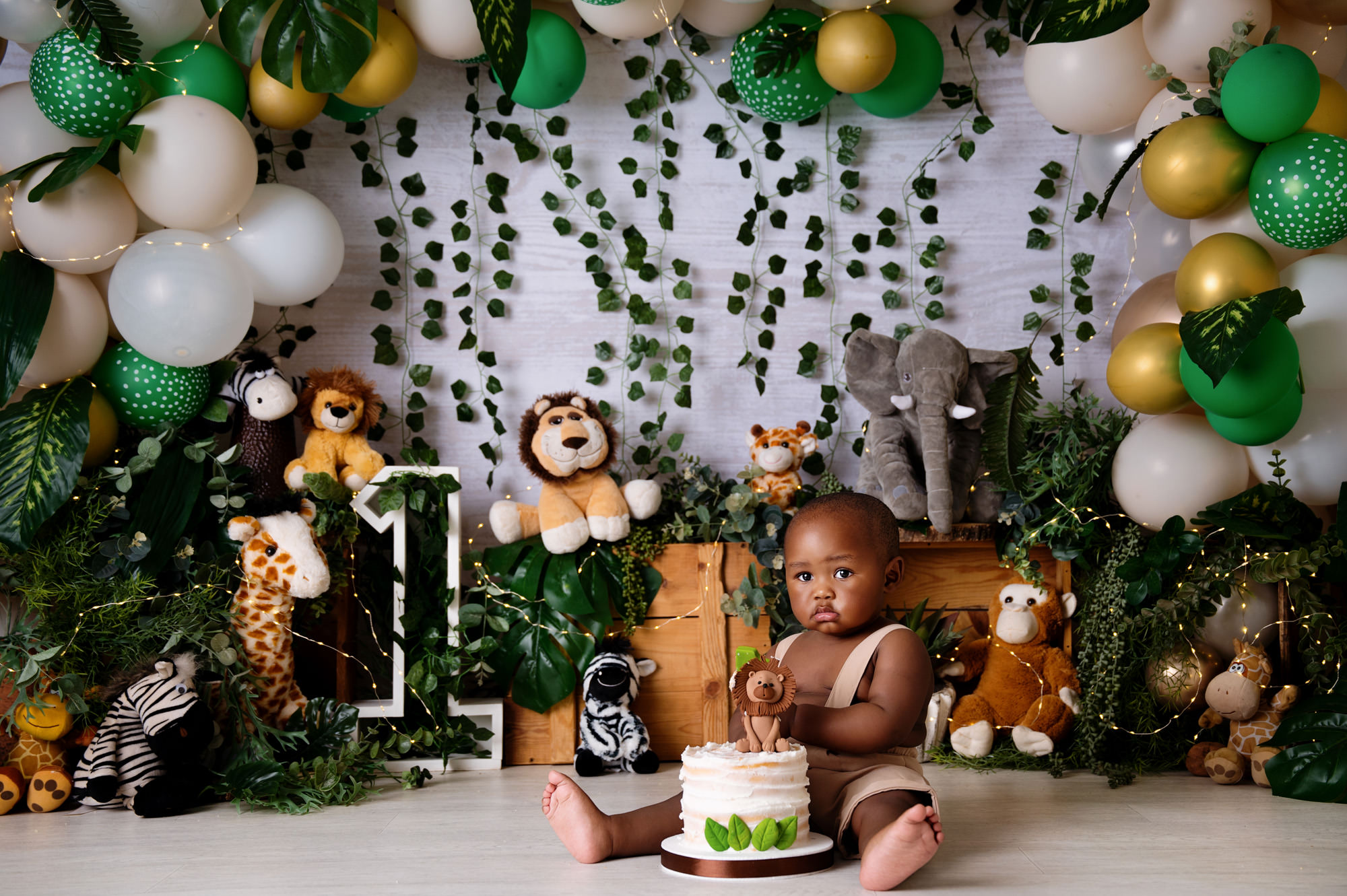 First birthday portrait with baby and cake in safari animal studio setup