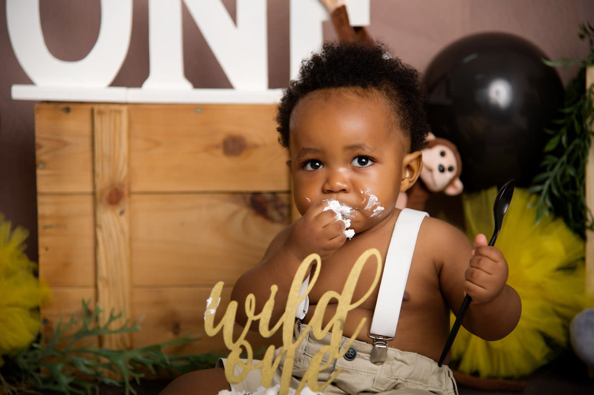 Close-up cake smash moment with baby boy enjoying cake – 1st birthday cake montana studio session.