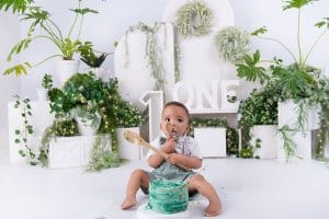 Baby Nkanyezi exploring his birthday cake surrounded by greenery