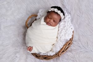 Baby Nomthandazo sleeping peacefully in white lace wrap — newborn photoshoot Pretoria by Jenna D Photography.