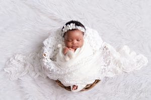 Baby Nomthandazo sleeping peacefully in white lace wrap — newborn photoshoot Pretoria by Jenna D Photography.