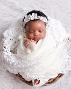 Baby Nomthandazo sleeping peacefully in white lace wrap — newborn photoshoot Pretoria by Jenna D Photography.