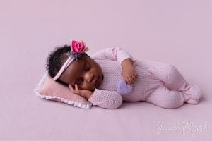 newborn on pink fabric