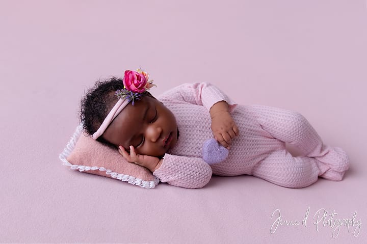older newborn asleep in soft pinks
