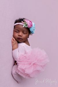 sleepy newborn on pink fabric