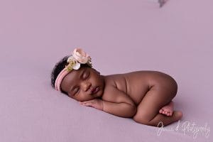 sleepy newborn on pink fabric