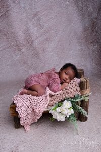sleepy newborn on pink fabric