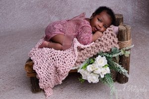 sleepy newborn on pink fabric