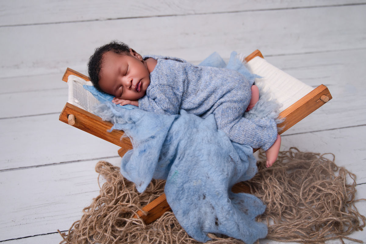 Peaceful newborn baby photographed in a calm studio environment, symbolising the gentle early days after birth.