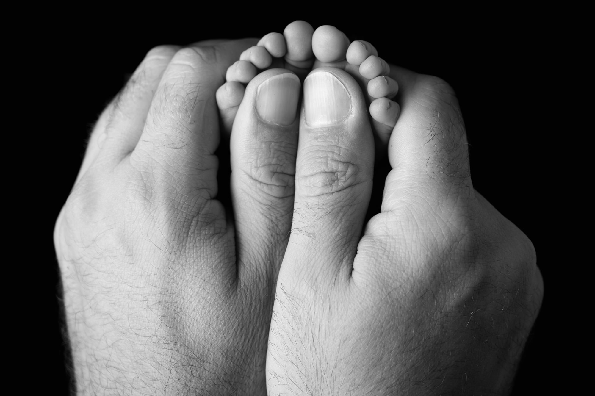 Close-up of newborn feet held by parent, capturing tender early days