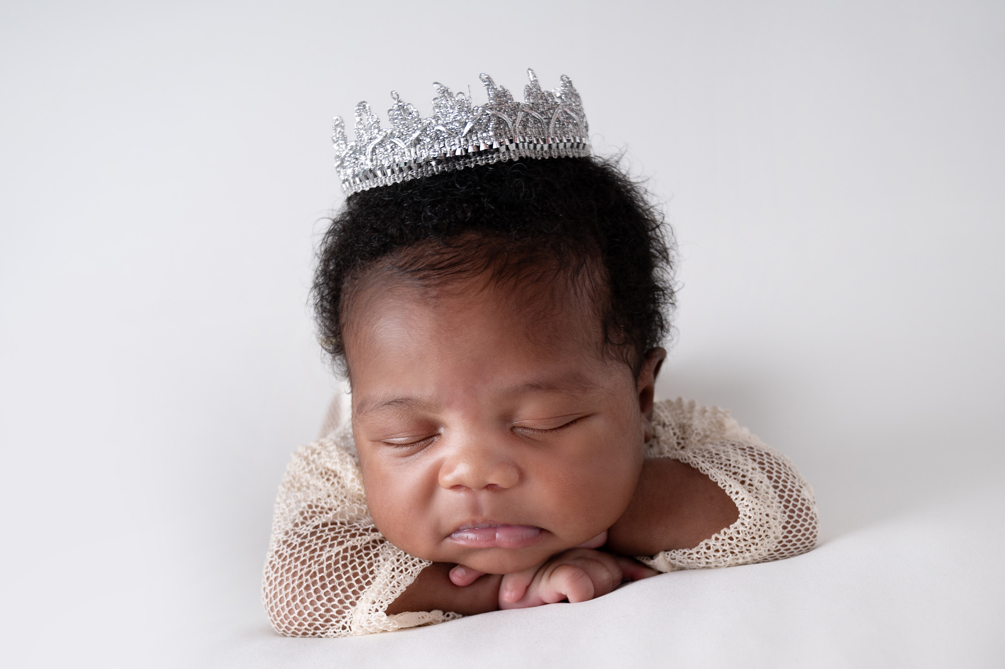 Newborn baby girl with delicate crown during studio session, representing early newborn care and Breastfeeding Support in Centurion.