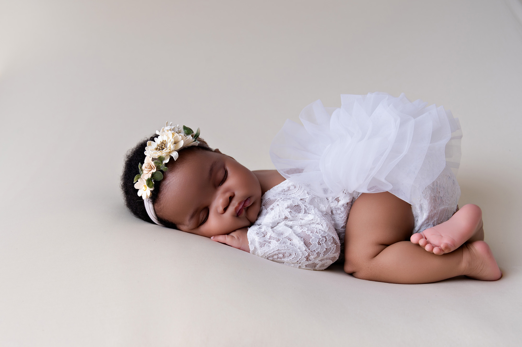 Newborn baby girl in white angel wings and floral headband, capturing the calm newborn stage supported by breastfeeding support options in Pretoria.