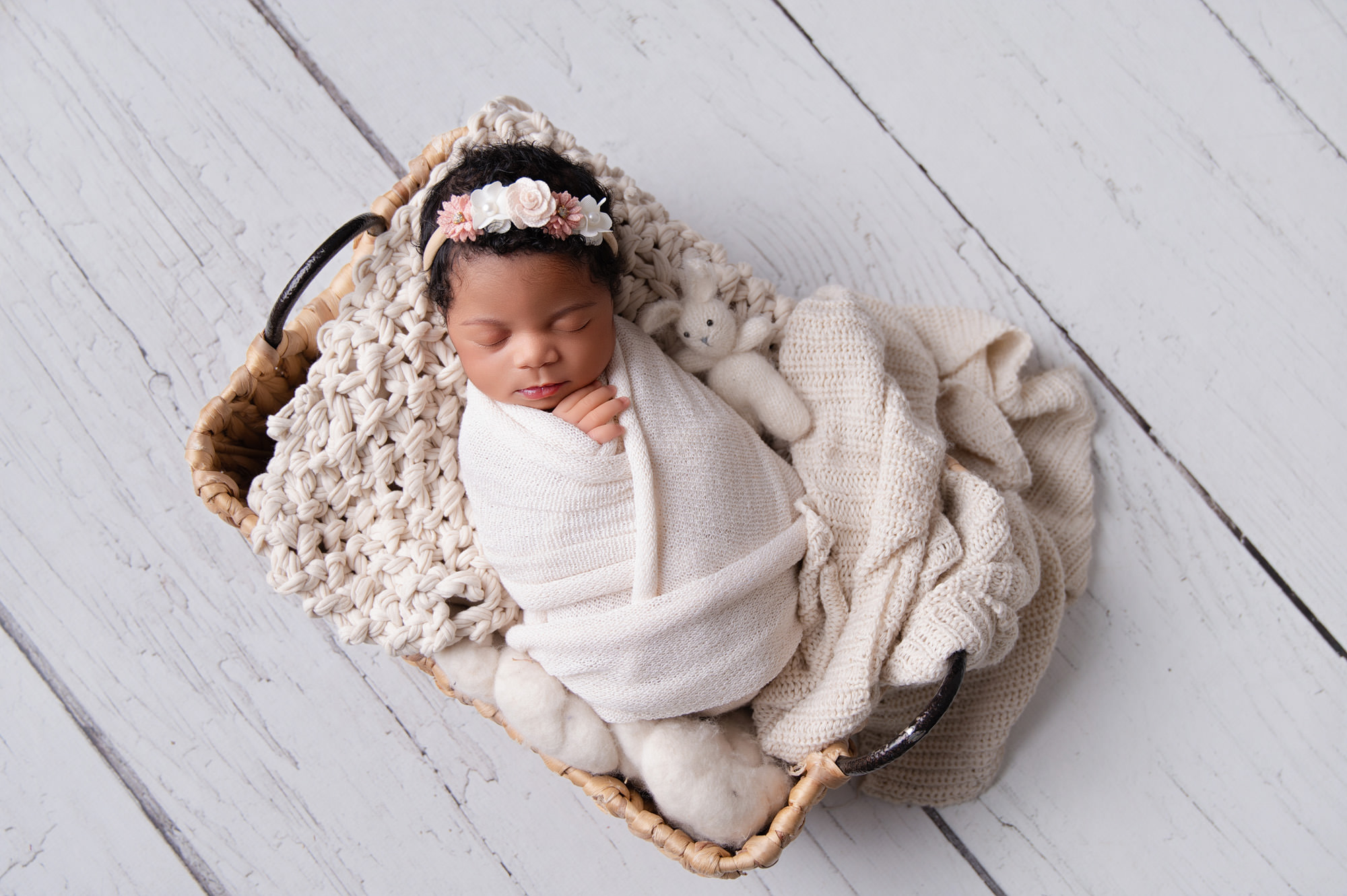 Sleeping newborn in a cosy cream basket setup