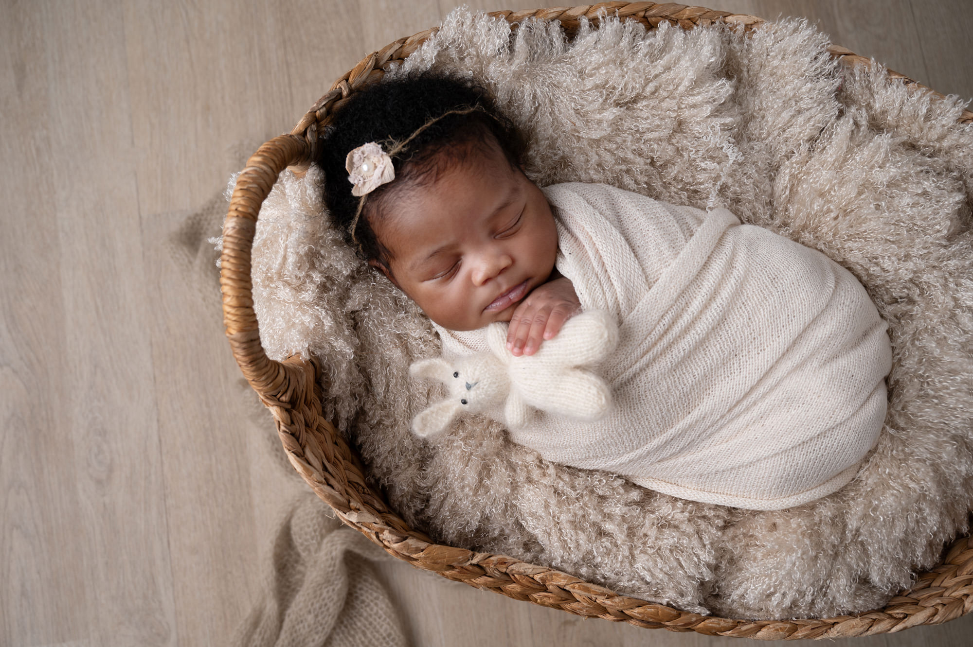 Newborn baby girl wrapped in cream inside woven basket, representing the peaceful early days connected to breastfeeding support options in Pretoria.