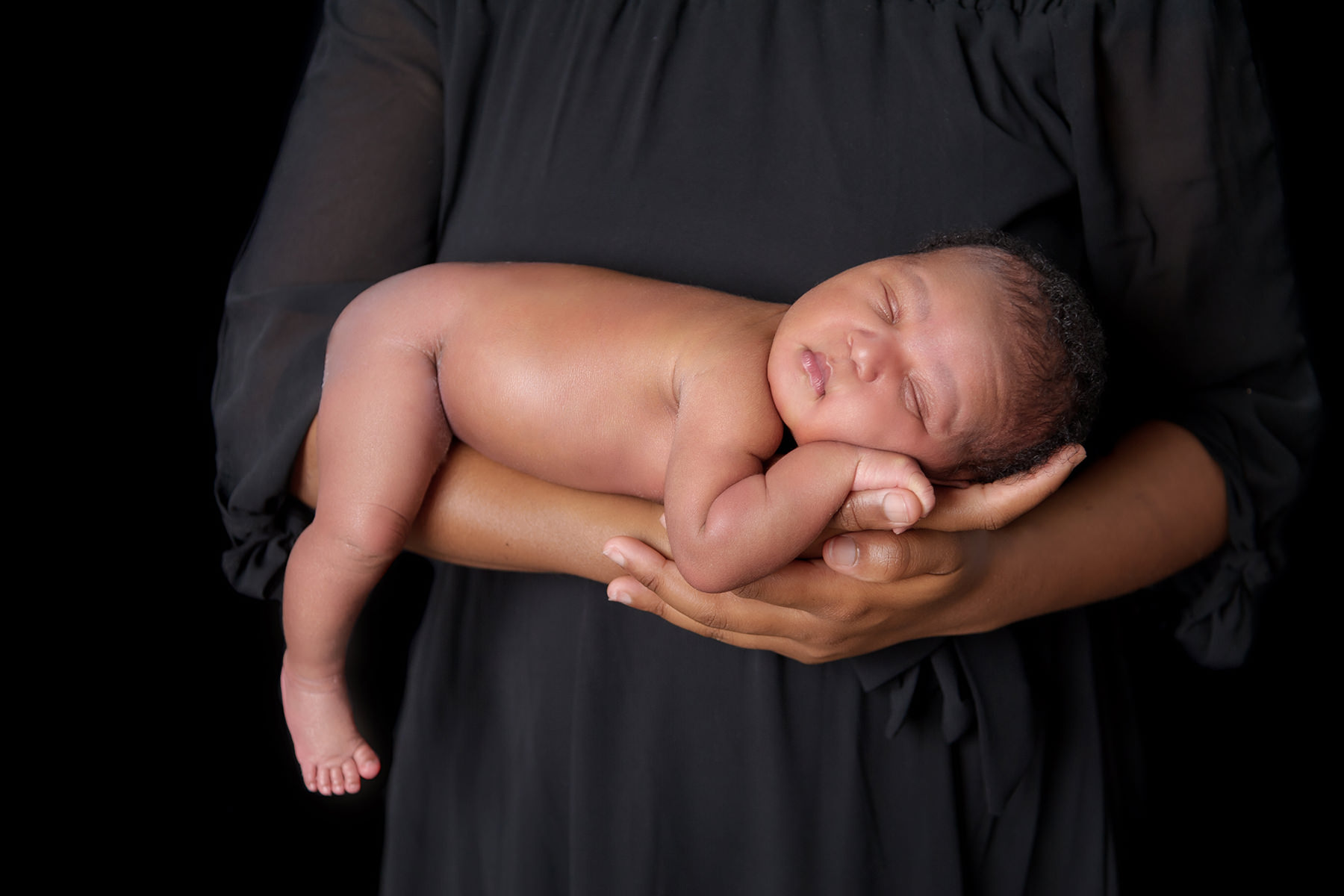 Newborn baby resting in parent’s arms during studio session, representing early parenting and Popular baby names South Africa trends