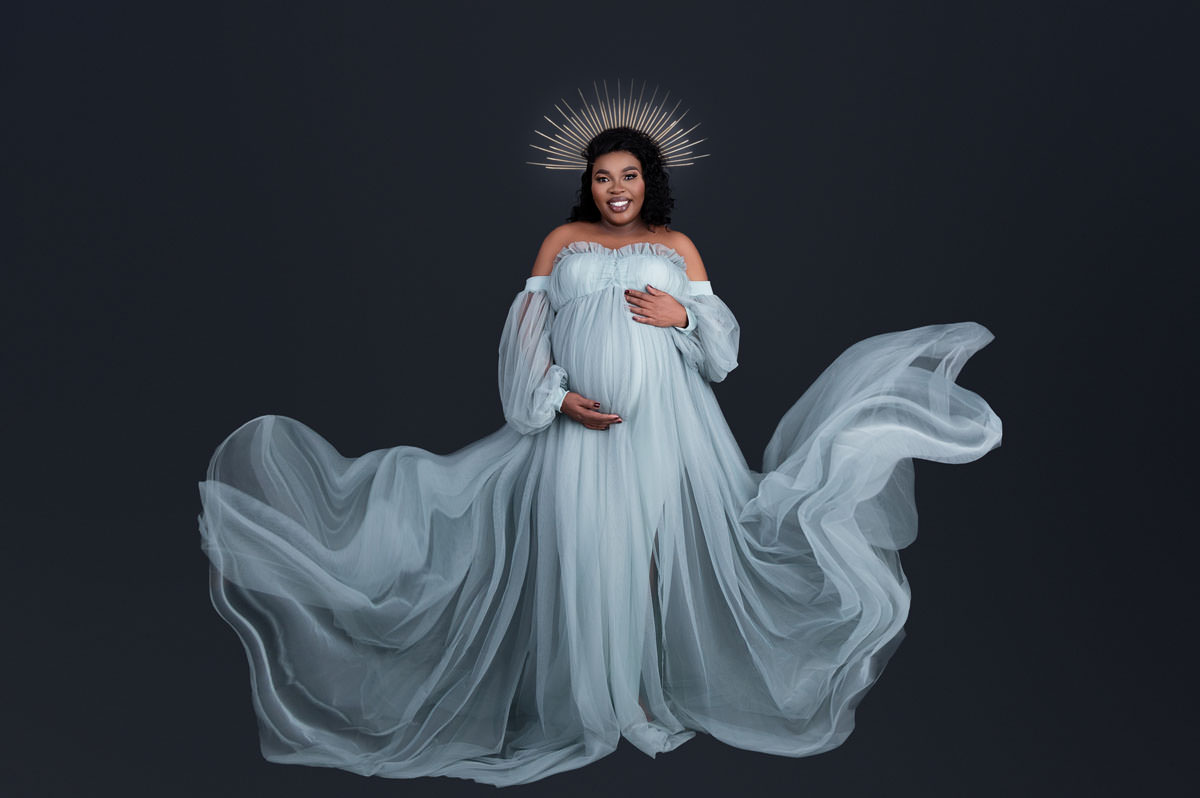 Fine-art maternity portrait with soft flowing fabric, symbolising calm pregnancy wellness