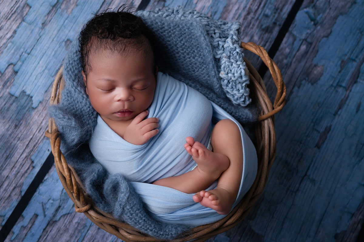 eaceful newborn baby sleeping on neutral blanket during studio session