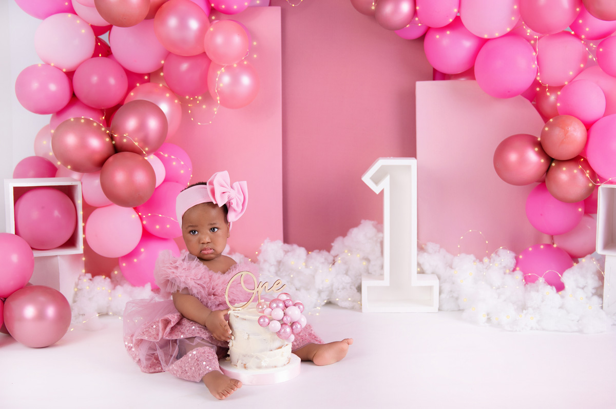 Bubble bath cake smash photo with baby girl and soft pink balloons – Pretoria cake smash session.