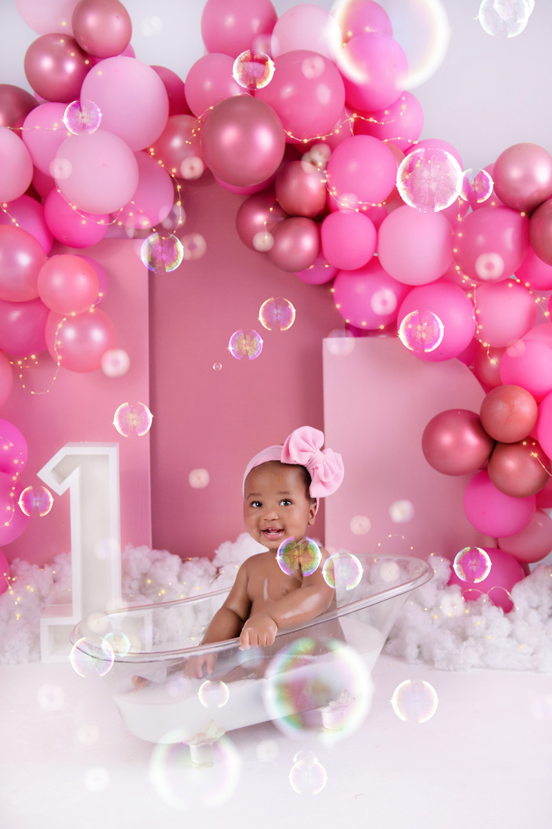 Bubble bath cake smash photo with baby girl and soft pink balloons – Pretoria cake smash session.