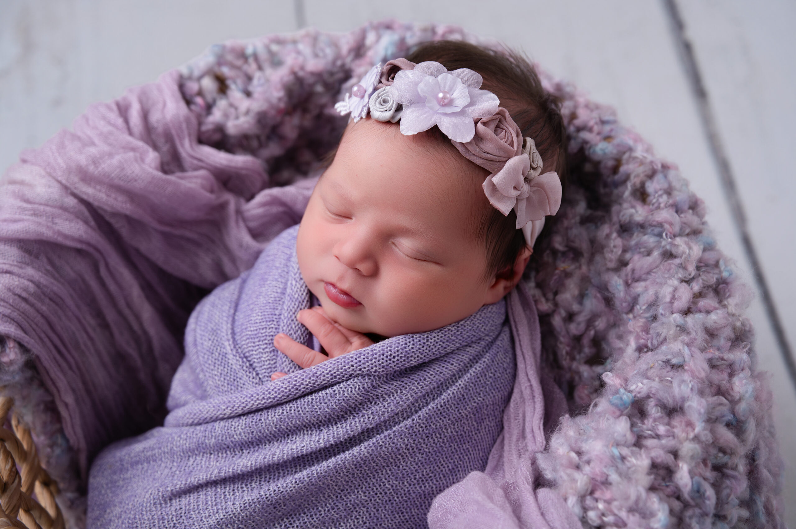 baby wrapped in purple in nursery compactum Baby Boutique